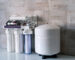 Household filtration system. Water treatment concept. Use of water filters at home. Glass of clean water and filters on a blurred background.